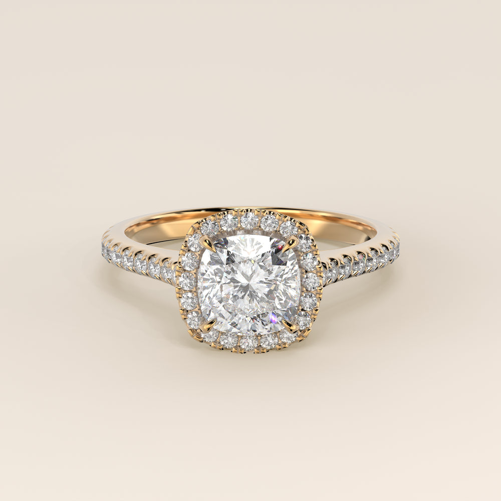 Bague de fiançailles en or jaune, sertie d'un diamant de laboratoire taille coussin, avec halo et pavage sur l'anneau.