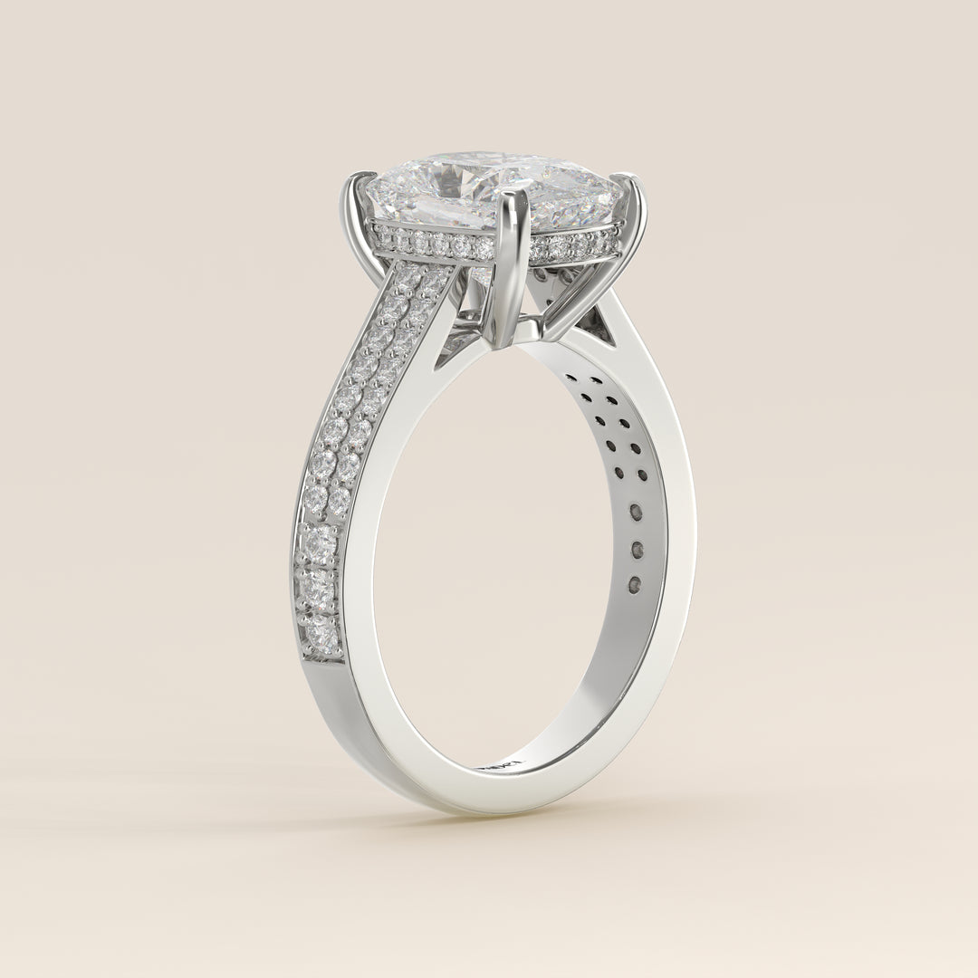 Bague de fiançailles en or blanc, sertie d'un diamant de laboratoire taille coussin allongé, avec un large pavage, serti cathédrale et halo invisible.