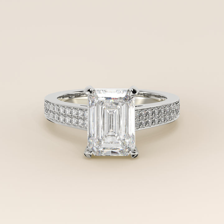 Bague de fiançailles en or blanc, sertie d'un diamant émeraude de synthèse, serti d'un pavé large et d'un halo discret.