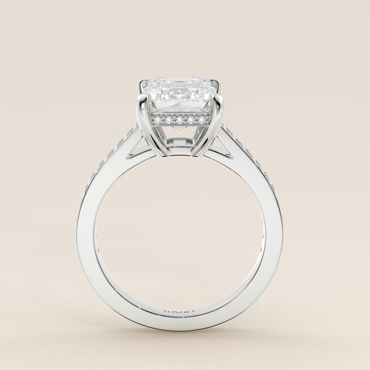 Bague de fiançailles en or blanc, sertie d'un diamant émeraude de synthèse, serti d'un pavé large et d'un halo discret.