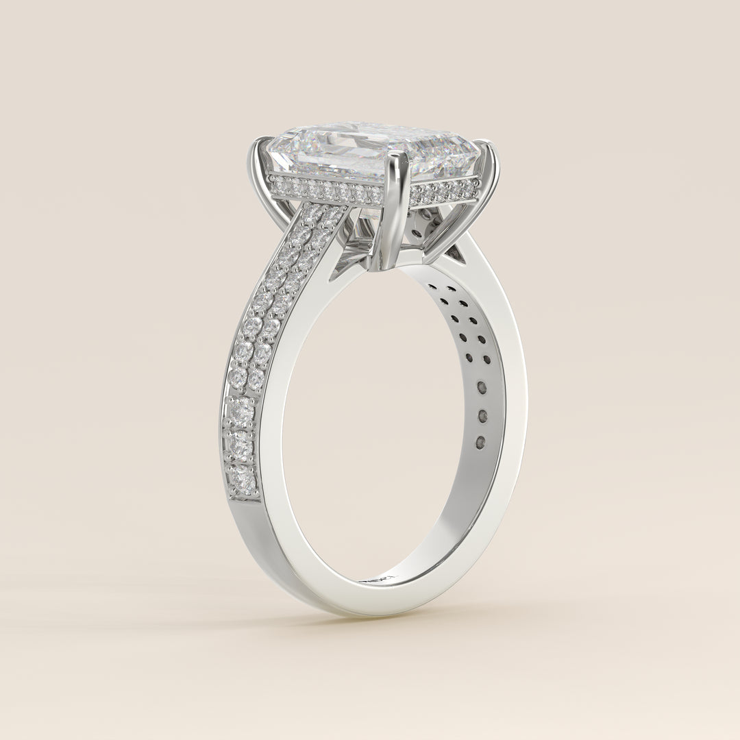 Bague de fiançailles en or blanc, sertie d'un diamant émeraude de synthèse, serti d'un pavé large et d'un halo discret.