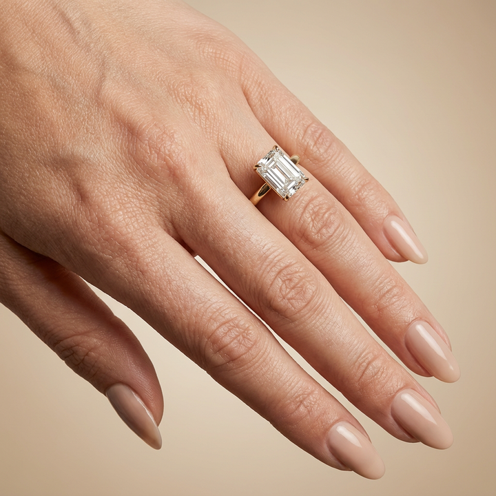 Bague de fiançailles en or jaune, sertie d'un diamant émeraude de synthèse avec halo discret.