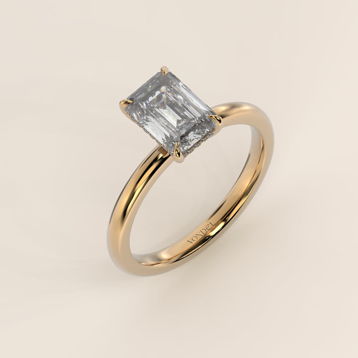 Bague de fiançailles en or jaune, sertie d'un diamant émeraude de synthèse avec halo discret.