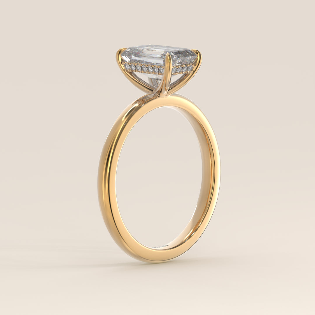Bague de fiançailles en or jaune, sertie d'un diamant émeraude de synthèse avec halo discret.