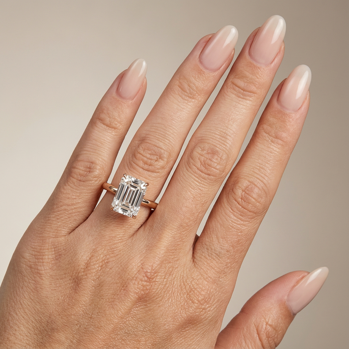 Bague de fiançailles en or rose, sertie d'un diamant de laboratoire émeraude et d'un halo discret.