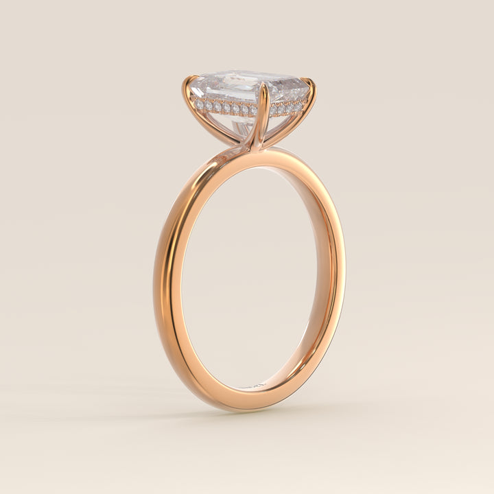 Bague de fiançailles en or rose, sertie d'un diamant de laboratoire émeraude et d'un halo discret.