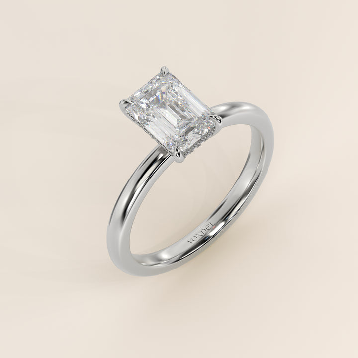 Bague de fiançailles en or blanc, sertie d'un diamant émeraude de laboratoire avec halo discret.