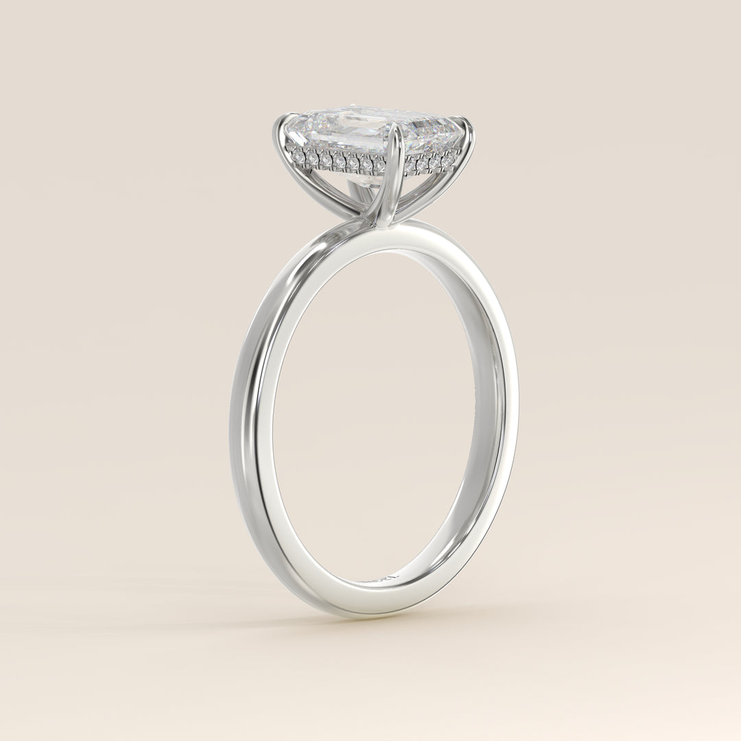 Bague de fiançailles en or blanc, sertie d'un diamant émeraude de laboratoire avec halo discret.