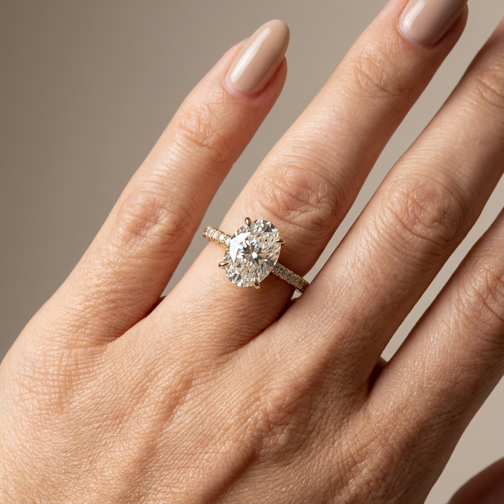 Verlovingsring ovaal lab grown diamant met cathedral zetting, pave band en hidden halo, geelgoud