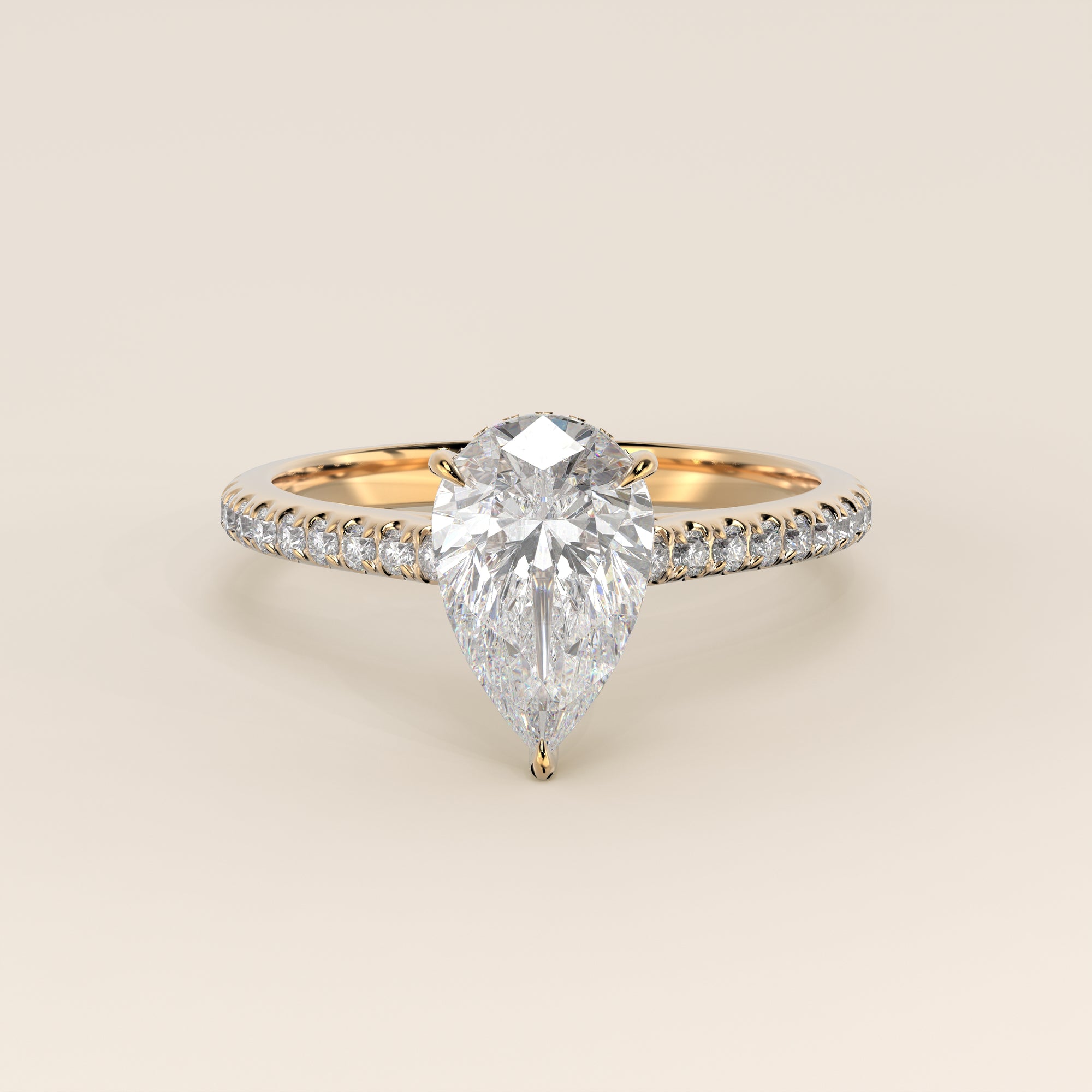Bague de fiançailles en or jaune, sertie d'un diamant de laboratoire taille poire, avec pavage et halo discret sur l'anneau pavé.