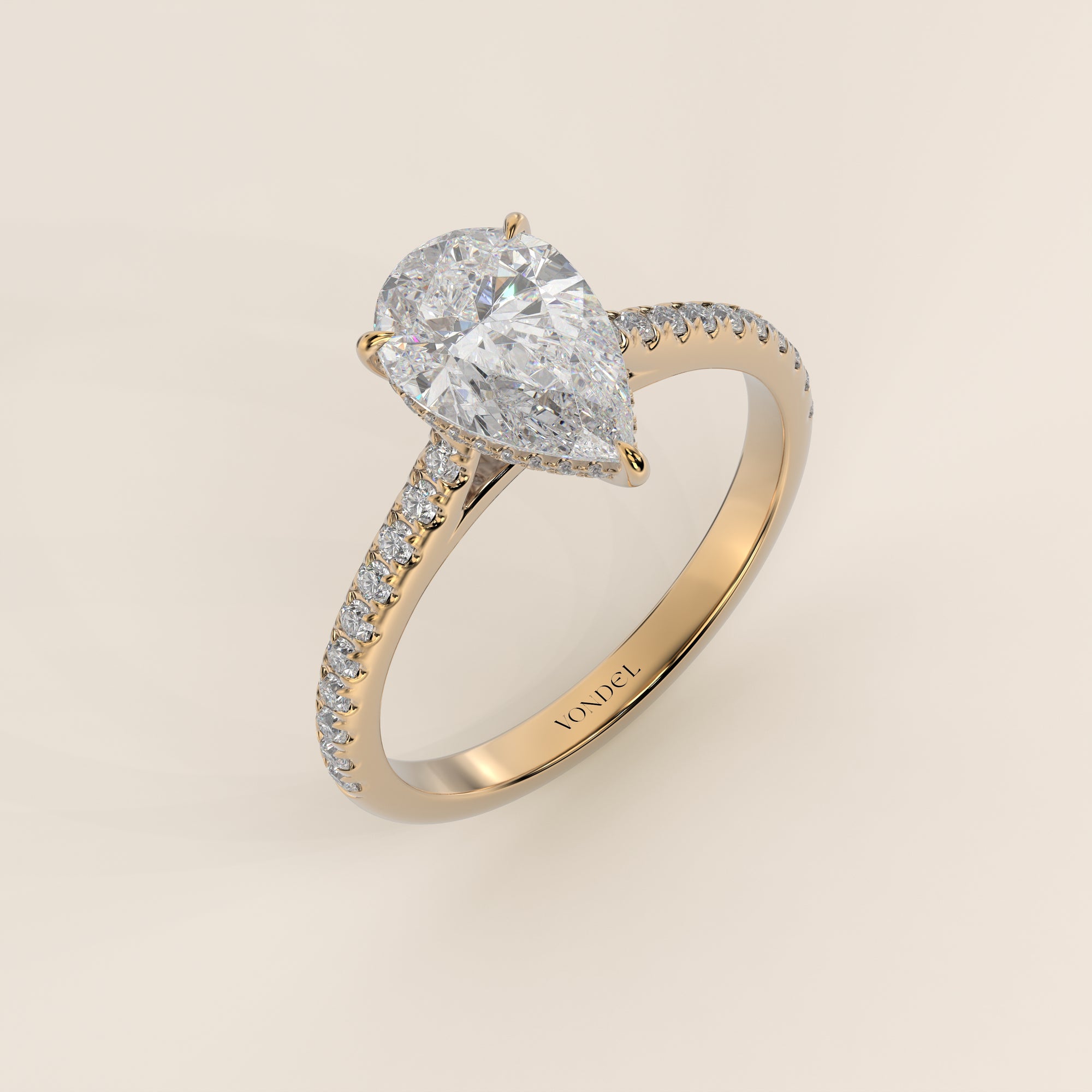 Bague de fiançailles en or jaune, sertie d'un diamant de laboratoire taille poire, avec pavage et halo discret sur l'anneau pavé.