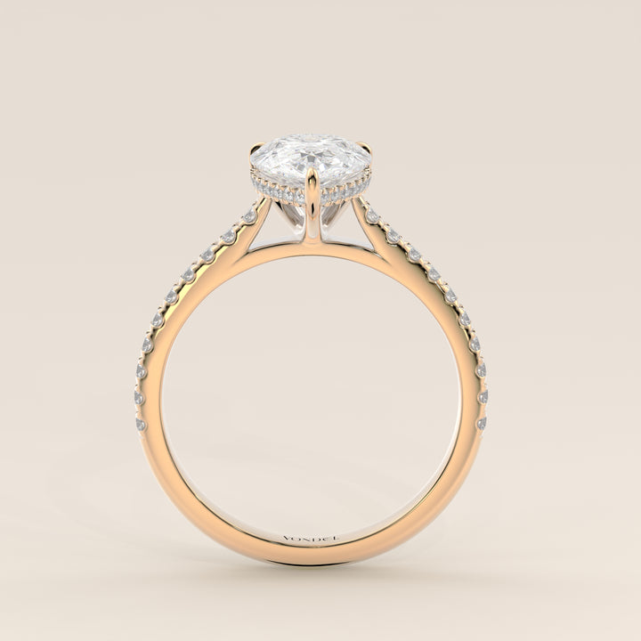 Bague de fiançailles en or jaune, sertie d'un diamant de laboratoire taille poire, avec pavage et halo discret sur l'anneau pavé.