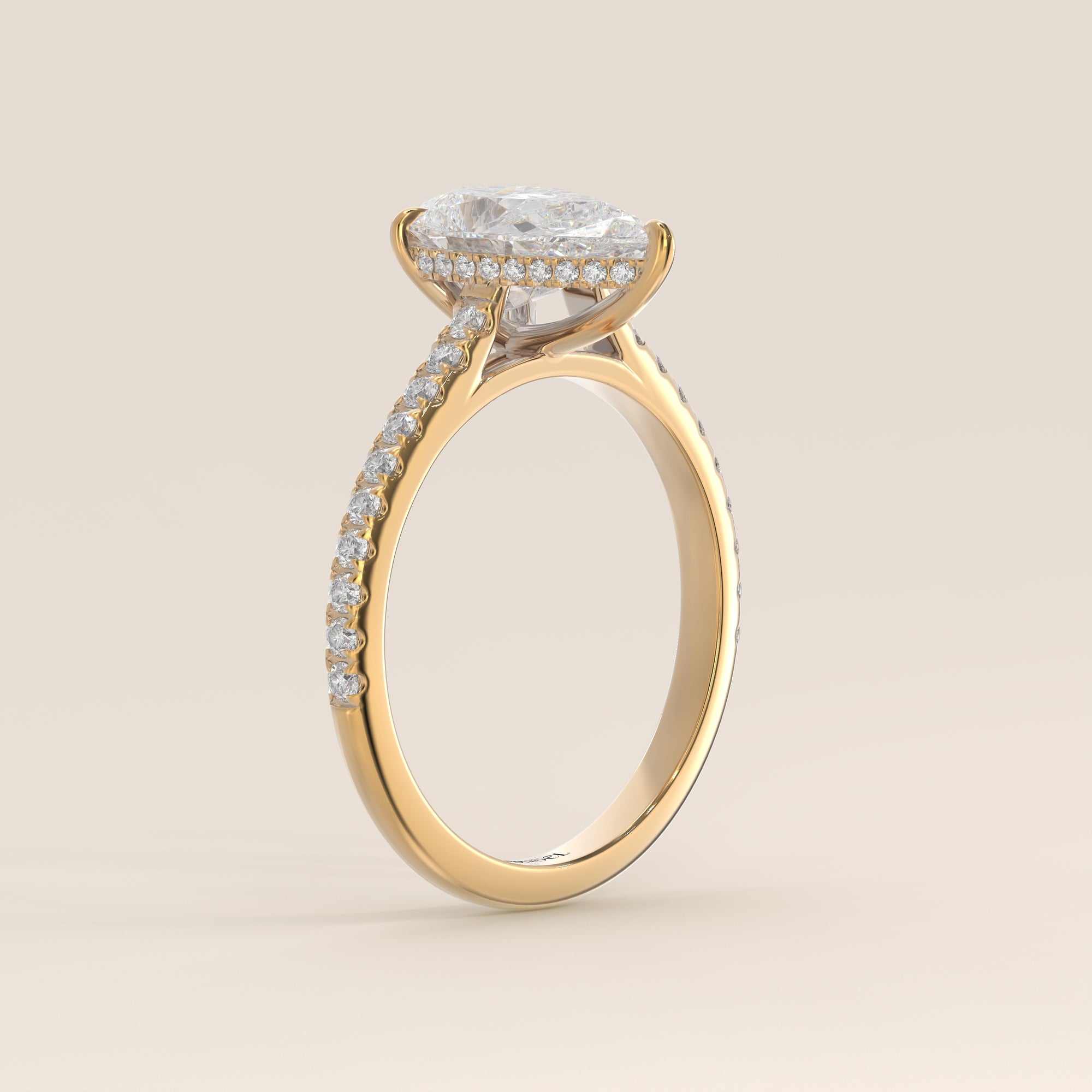 Bague de fiançailles en or jaune, sertie d'un diamant de laboratoire taille poire, avec pavage et halo discret sur l'anneau pavé.