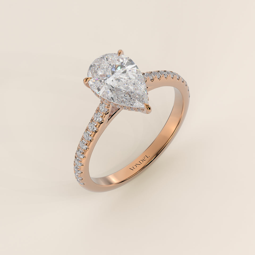 Bague de fiançailles en or rose, sertie d'un diamant de laboratoire taille poire, avec pavage et halo discret sur l'anneau pavé.