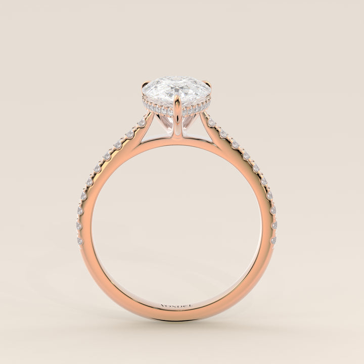 Bague de fiançailles en or rose, sertie d'un diamant de laboratoire taille poire, avec pavage et halo discret sur l'anneau pavé.