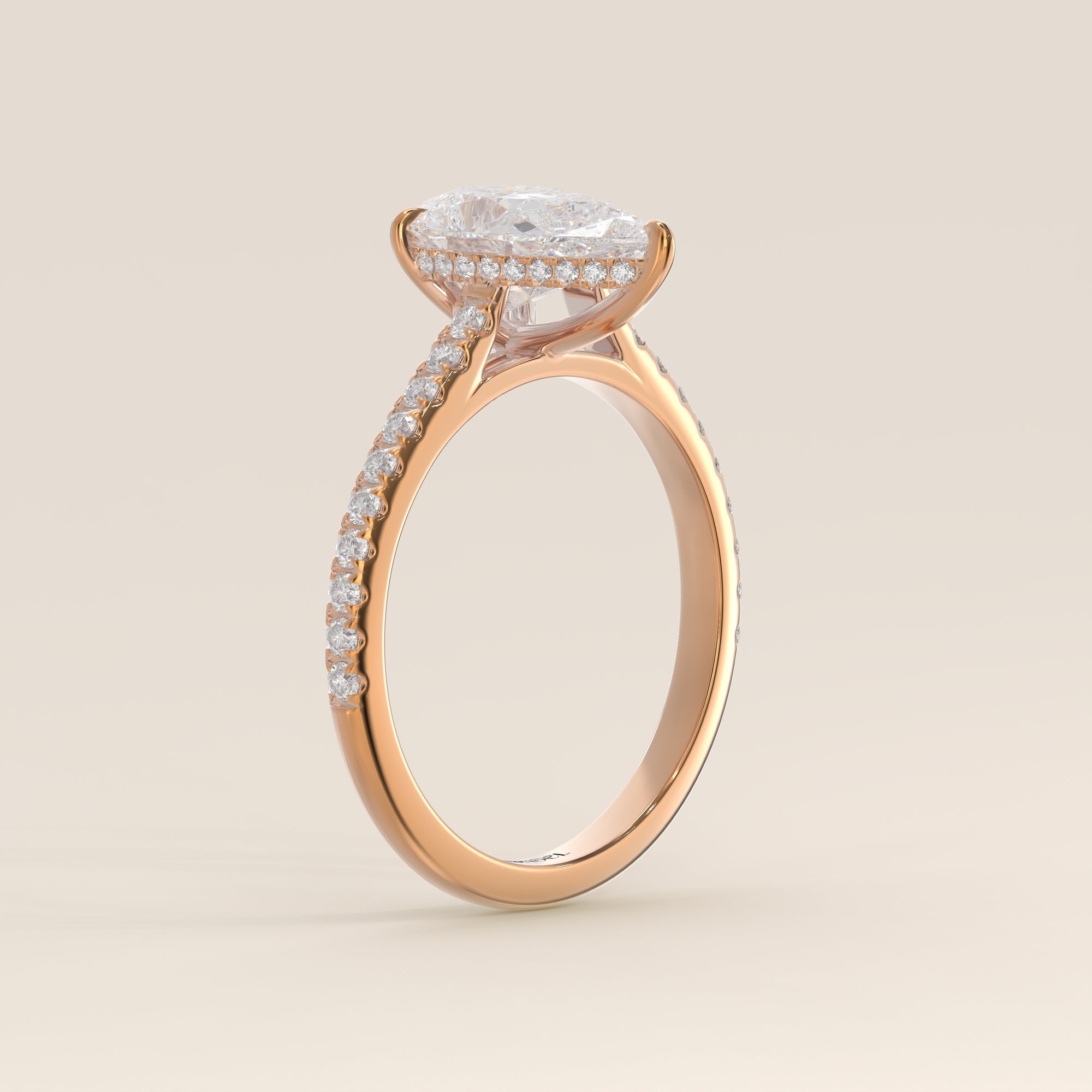 Bague de fiançailles en or rose, sertie d'un diamant de laboratoire taille poire, avec pavage et halo discret sur l'anneau pavé.