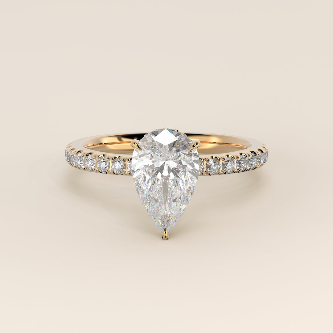 Bague de fiançailles en or jaune, sertie d'un diamant poire de laboratoire avec halo discret et pavage sur l'anneau.