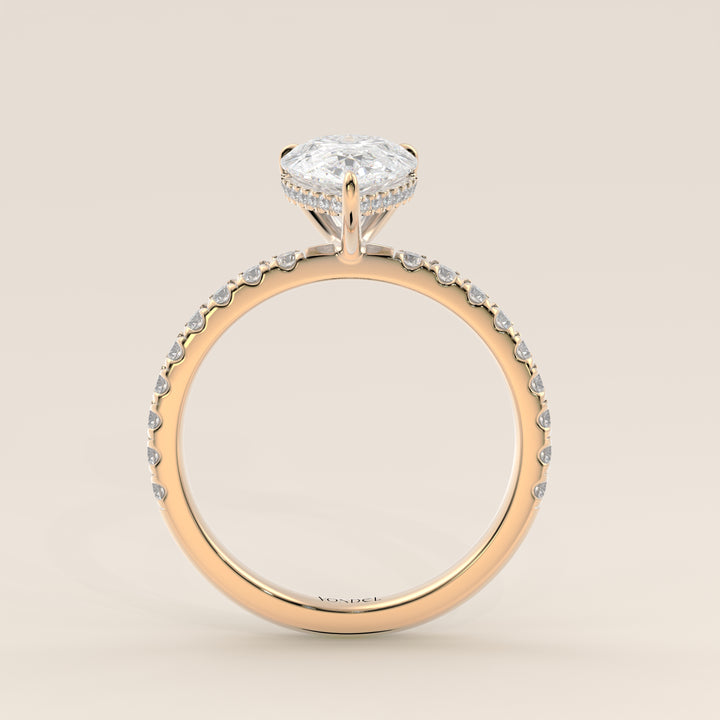 Bague de fiançailles en or jaune, sertie d'un diamant poire de laboratoire avec halo discret et pavage sur l'anneau.