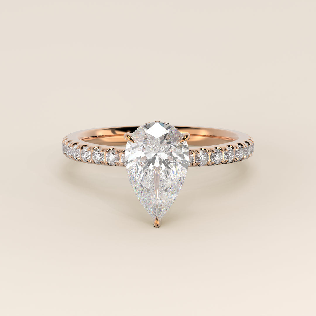 Bague de fiançailles en or rose, sertie d'un diamant de laboratoire taille poire avec halo discret et anneau pavé.