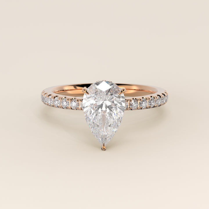 Bague de fiançailles en or rose, sertie d'un diamant de laboratoire taille poire avec halo discret et anneau pavé.