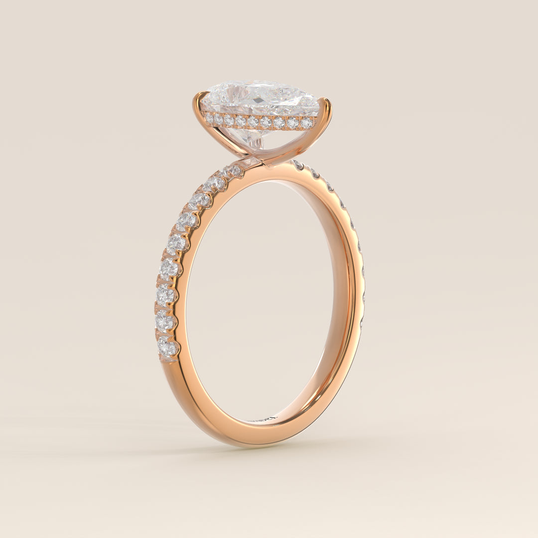 Bague de fiançailles en or rose, sertie d'un diamant de laboratoire taille poire avec halo discret et anneau pavé.