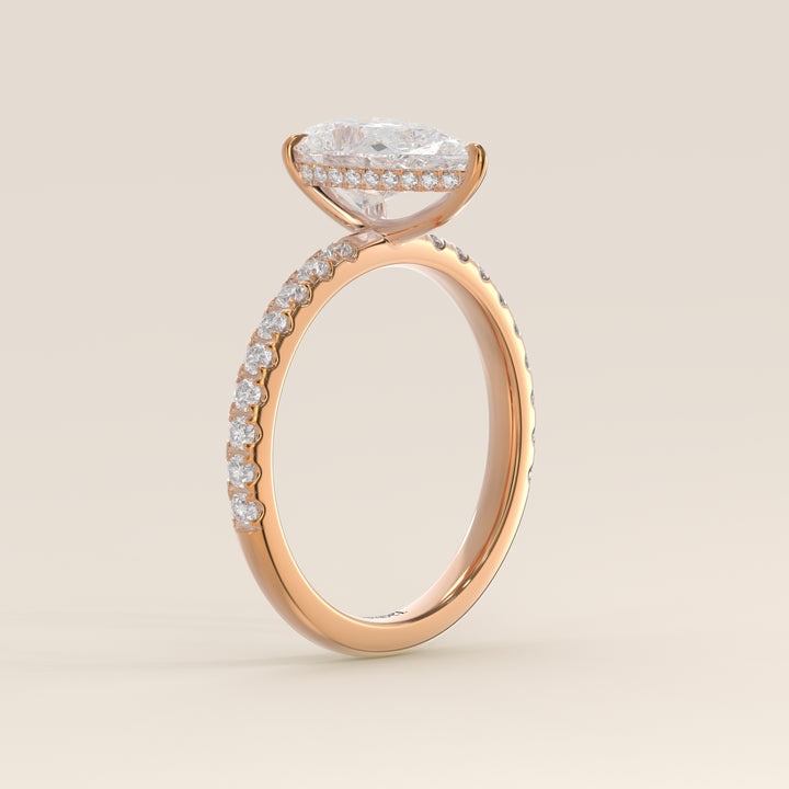 Bague de fiançailles en or rose, sertie d'un diamant de laboratoire taille poire avec halo discret et anneau pavé.