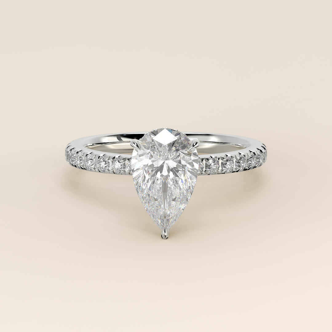 Bague de fiançailles en or blanc, sertie d'un diamant de laboratoire taille poire avec halo discret et pavage sur l'anneau.