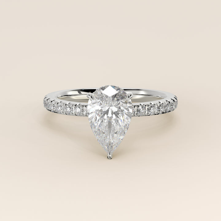 Bague de fiançailles en or blanc, sertie d'un diamant de laboratoire taille poire avec halo discret et pavage sur l'anneau.