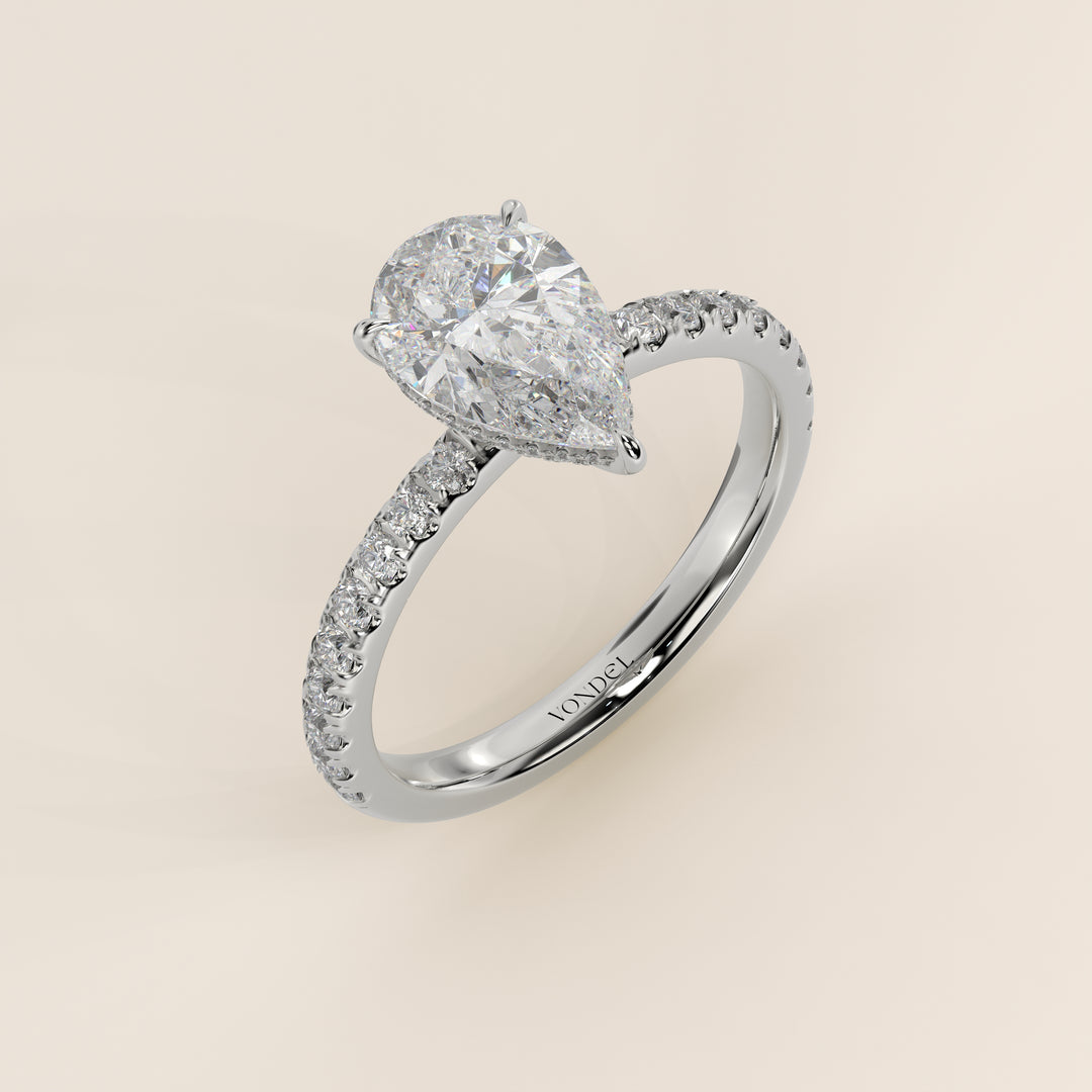 Bague de fiançailles en or blanc, sertie d'un diamant de laboratoire taille poire avec halo discret et pavage sur l'anneau.