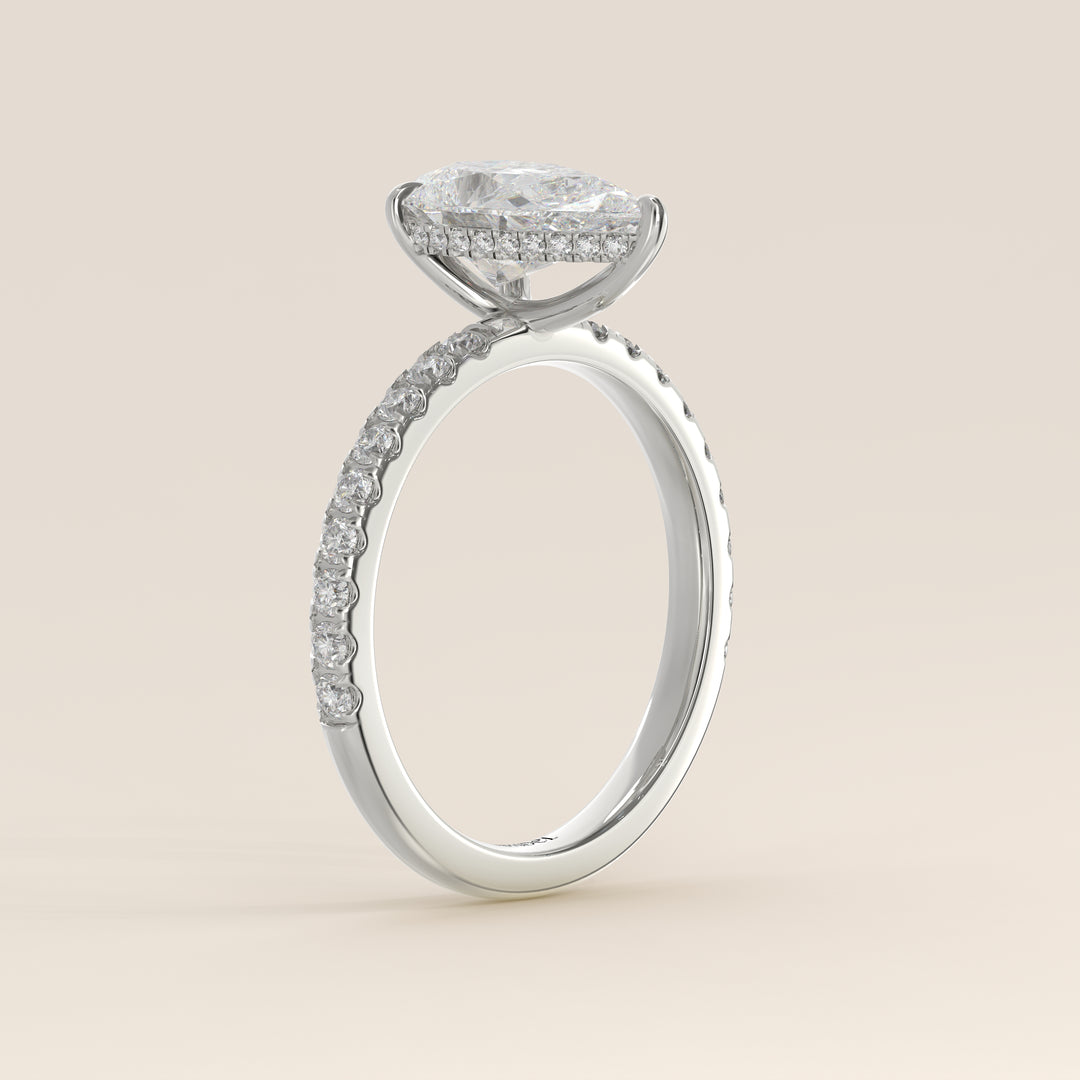 Bague de fiançailles en or blanc, sertie d'un diamant de laboratoire taille poire avec halo discret et pavage sur l'anneau.