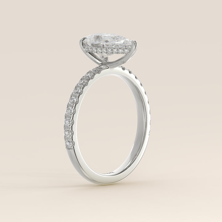 Bague de fiançailles en or blanc, sertie d'un diamant de laboratoire taille poire avec halo discret et pavage sur l'anneau.
